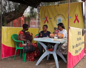 A mother consults with health workers in Tanzania.